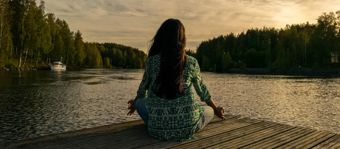 A person meditating in nature, symbolising recreational alternative medicine.
